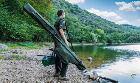 How to find carp  - Man holding carp gear looking for fish