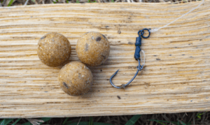 how to catch carp from a river - rig hook on table with boilies