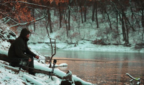 when-are-carp-most-active-man-sitting-by-lake-in-the-snow