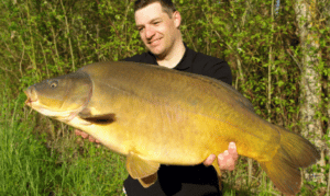 What is a leather carp - angler holding large leather carp